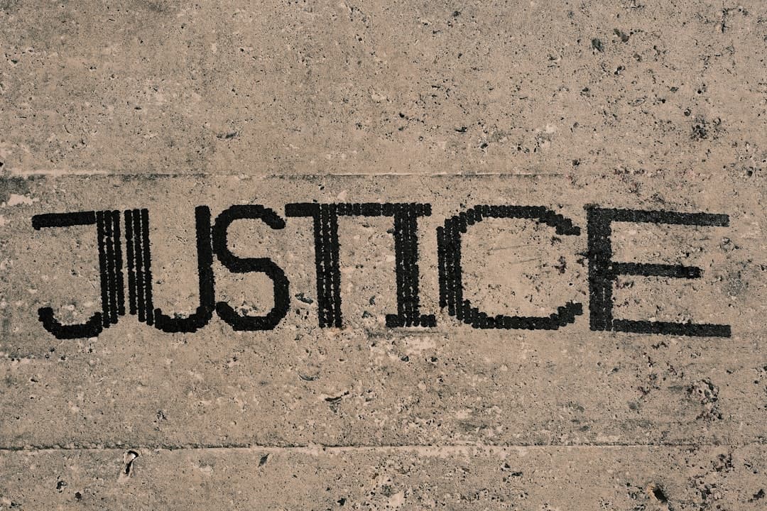 The word "JUSTICE" stenciled in black on a concrete wall.